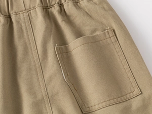 Close-up of khaki boys casual pants with elastic waistband and square back pocket detail