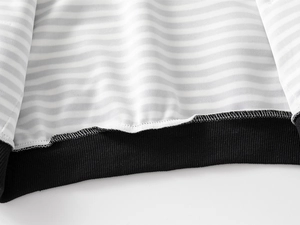 Détail de la doublure rayée et de l'ourlet côtelé noir sur le sweat enfant