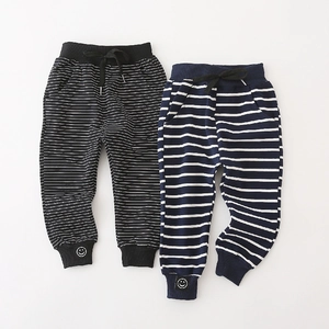 Boys striped jogger pants with elastic waist and smiley patch in black and navy colors