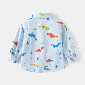 Dettaglio delle stampe di dinosauri sulla camicia in cotone azzurro per bambini