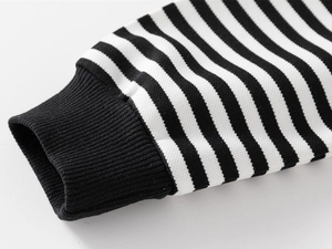 Détail de manche à rayures noires et blanches avec poignets en maille côtelée pour enfant
