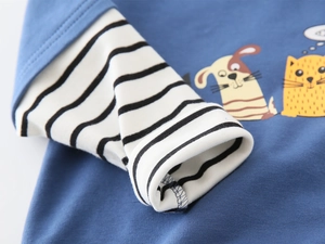 Detail of blue cotton hoodie featuring black and white striped cuffs and cartoon animals