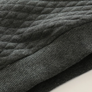 Detail von dunkelgrauem Steppstoff und Rippbündchen an einem dicken Kinder-Sweatshirt