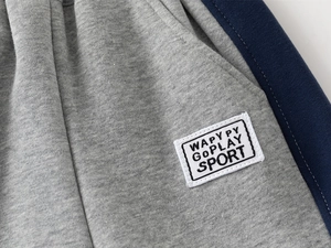 Detail of gray knit boys' joggers with blue side stripes and sport style patch
