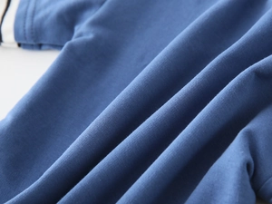 Close-up of navy blue knit fabric with contrast stripe stitching and high-quality texture