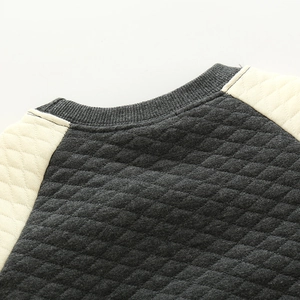 Nahaufnahme des gesteppten Kinder-Sweatshirts mit grauem Rautenmuster und Nähten