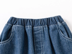 Detail of boys' navy denim shorts showing elastic waistband and white contrast stitching