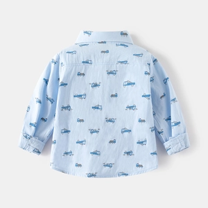Detailed back view of boy's light blue shirt with cartoon truck print and fine cotton texture