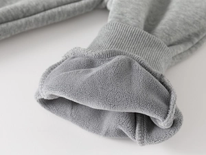 Detail of ribbed cuffs and thick gray fleece lining on children's winter sports pants
