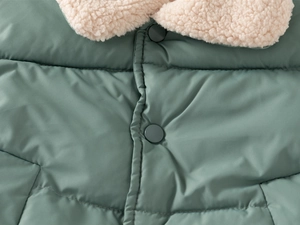 Detail of green quilted vest collar with soft faux shearling lining and matte snaps