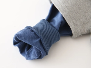 Detail of color-block hooded sweatshirt showing ribbed navy cuffs and french terry lining