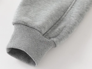 Macro detail of ribbed cuffs and stitching on thick heather grey fleece joggers