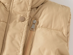 Detail of metal zipper and snap buttons on quilted padded winter vest for boys