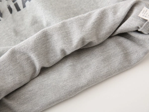Macro shot of grey hoodie interior showing soft knit texture and brand care label detail