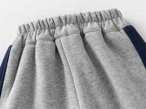 Detail of boys thickened sports joggers showing the elastic waistband and gray knit fabric