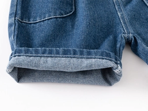 Detail of blue denim shorts showing white double-stitch seams and folded hem craft