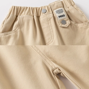 Detail of children's khaki cotton pants featuring elastic waist and woven label