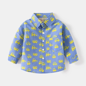 Detail of blue cotton kids shirt with yellow cartoon excavator prints and front pocket