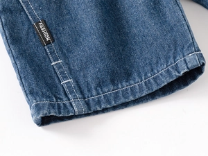 Macro detail of boys denim shorts showing the FASHION label and white double stitching