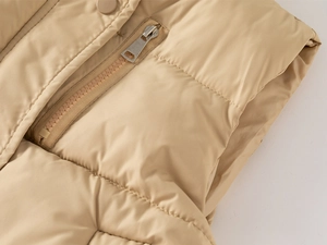Macro view of boy's winter quilted vest showing metal zipper pocket and matching snap button