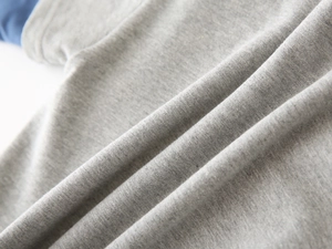 Detail of grey heather knit fabric with blue color-blocked sleeve stitching