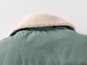 Detail of sage green winter vest featuring a thick cream sherpa fleece lining and collar