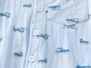 Close-up of light blue cotton shirt with cartoon construction vehicle patterns and buttons