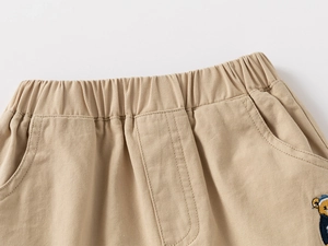 Dettaglio pantaloncini in cotone kaki con vita elastica e ricamo a orsetto per bambini
