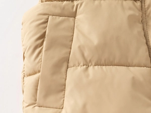 Close-up of side pocket detail on beige padded winter vest with windproof fabric
