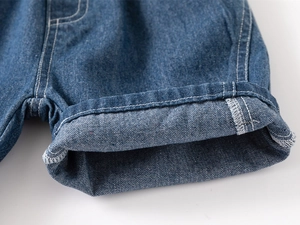 Macro detail of boys' denim shorts featuring rolled cuffs and contrast stitching lines