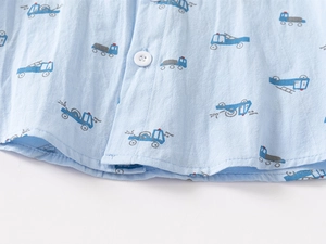 Macro shot of breathable cotton fabric with blue truck prints and neat stitching