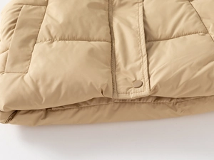 Macro detail of khaki quilted vest showing premium stitching and snap button closure
