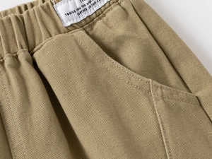 Detail of boys khaki casual pants featuring elastic waistband and twill cotton texture