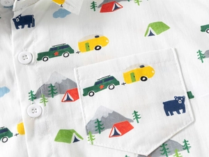 Close-up of kids' cartoon camping print shirt showing pocket detail and white buttons