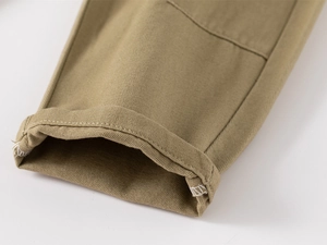 Detail of khaki twill cotton trousers showing hem stitching and rolled cuff design