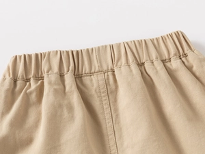 Dettaglio della vita elastica su pantaloncini in cotone kaki per bambini con cuciture