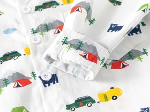 Close-up of camping-themed digital prints and white buttons on a cotton kid's shirt