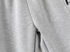 Vue détaillée d'un pantalon de sport gris avec coutures renforcées et broderie