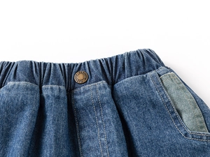 Détail du short en jean pour garçon avec taille élastique et bouton métallique gravé