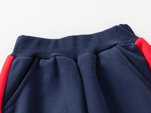 Détail du jogging enfant bleu marine avec taille élastiquée et bande latérale rouge