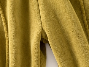 Close-up of mustard green polar fleece fabric with premium double-stitch sewing detail
