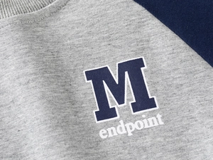 Close-up of boys' sports sweatshirt showing grey and navy knit fabric and M print