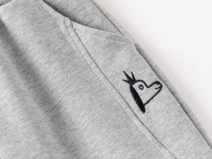 Détail du jogging gris pour garçon avec broderie d'animal à couronne et poche latérale