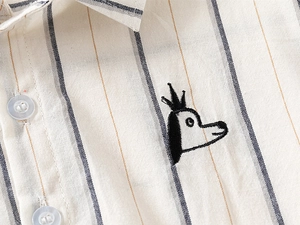 Close-up of children's striped linen shirt featuring crown dog embroidery and pearl buttons