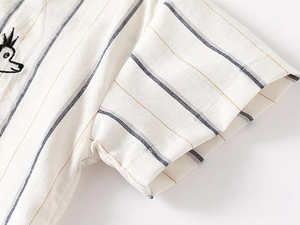 Detail of kids striped shirt featuring crown animal embroidery and cotton linen texture