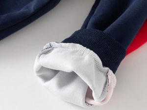 Détail du poignet en tricot bleu marine avec doublure en polaire blanche douce et couture