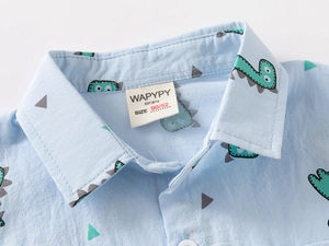 Close-up of the collar area on a light blue cotton shirt with cartoon dinosaur prints