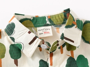 Close-up of boys' cotton linen shirt collar with forest print and woven brand label