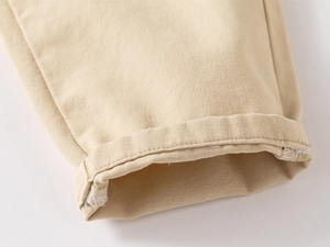 Detail view of khaki cotton twill pants showing high-quality stitching and rolled cuff design
