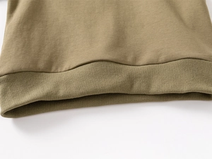 Detail shot of the elastic ribbed hem on this olive green cotton kids sweatshirt